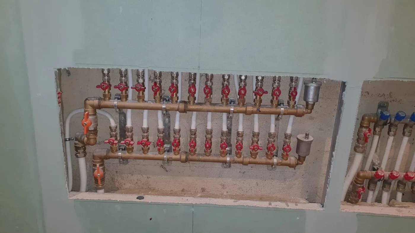 Collecteur de distribution en cuivre encastré dans un mur, avec vannes d'arrêt individuelles