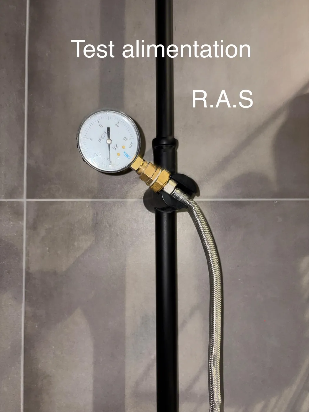 Manomètre raccordé sur une alimentation d'eau pour un essai de mise en pression, annoté « Test alimentation R.A.S »