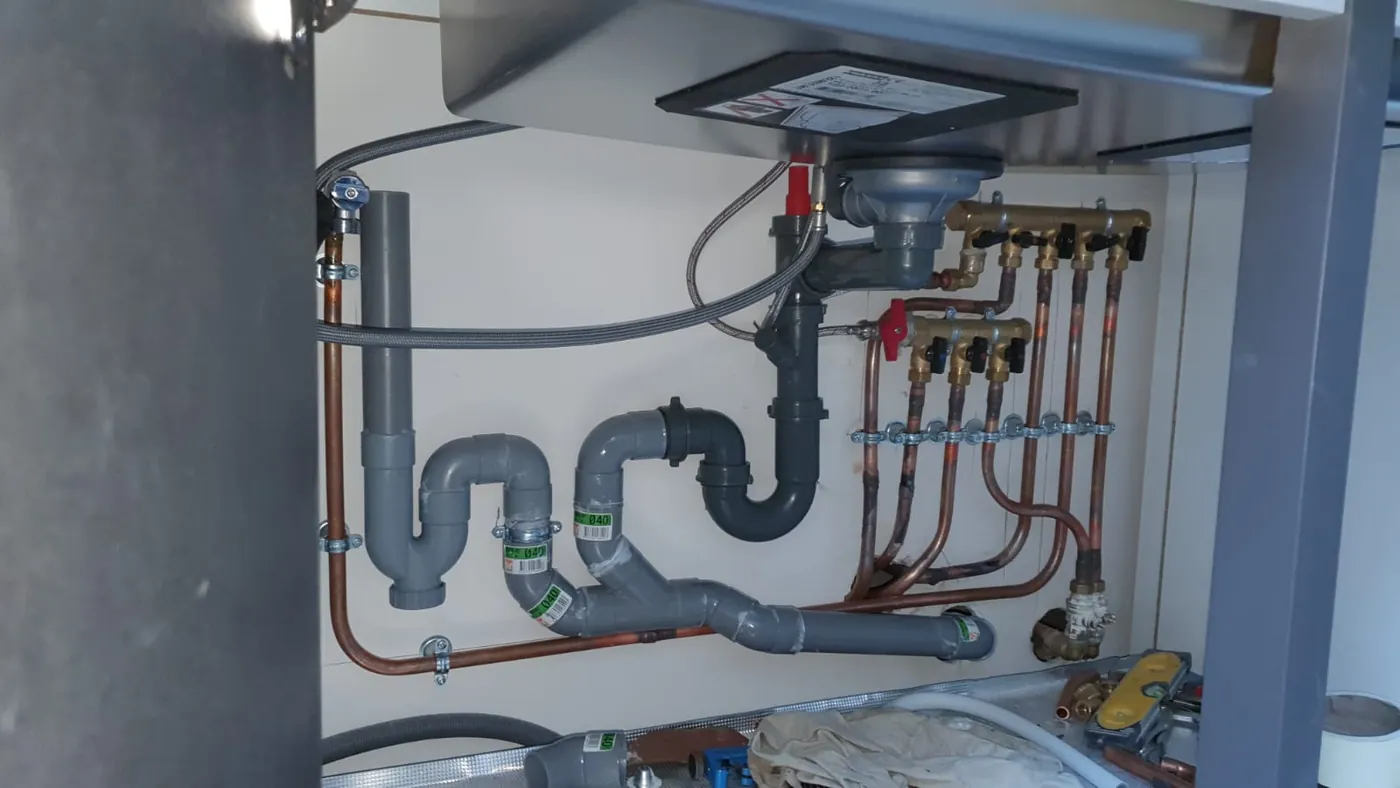 Nourrice en cuivre et collecteurs sous chauffe-eau, avec évacuations PVC et vannes d'arrêt