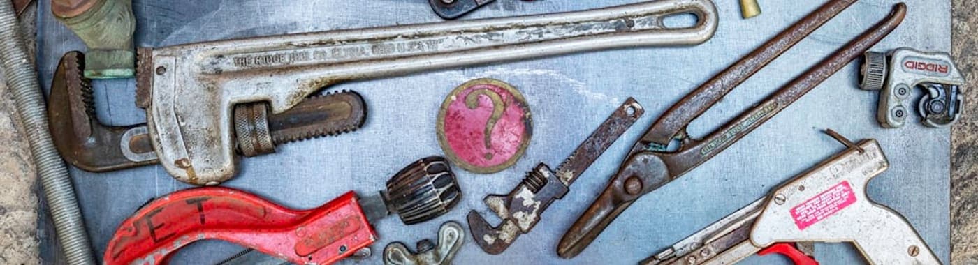 Outils de plomberie professionnels, clés et raccords disposés sur un établi